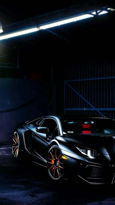 A single fluorescent tube along the ceiling is the only light in the garage, throwing a hard streak down the roof and shoulder of the Lamborghini.