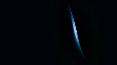 One narrow crescent of pale blue light stands near the centre of a pitch-black frame, its glow falling away within a finger's width.