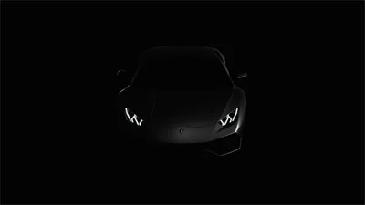 The Lamborghini faces the camera in near total darkness, its Y-shaped daytime lamps and a faint edge along the bonnet the only things visible.