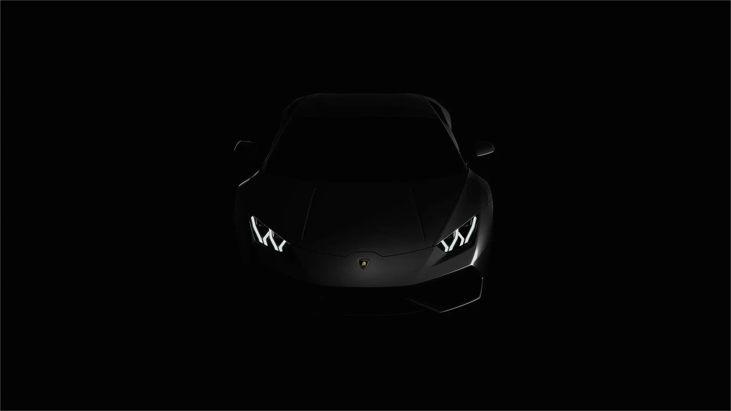 The Lamborghini faces the camera in near total darkness, its Y-shaped daytime lamps and a faint edge along the bonnet the only things visible.