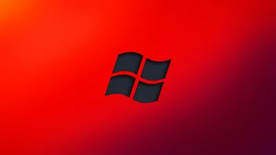 The four-pane mark sits cut out in black at the centre of a red field that deepens toward the edges.