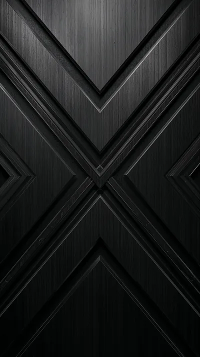 Large chevrons meet in the middle of a tall panel of brushed dark metal, the grain running sideways and the bevels catching a thin line of light.