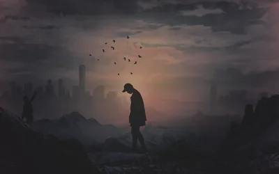 A flock of birds lifts away above a man standing head-down on rubble, the hazy skyline behind him keeping the top corners soft and dark.