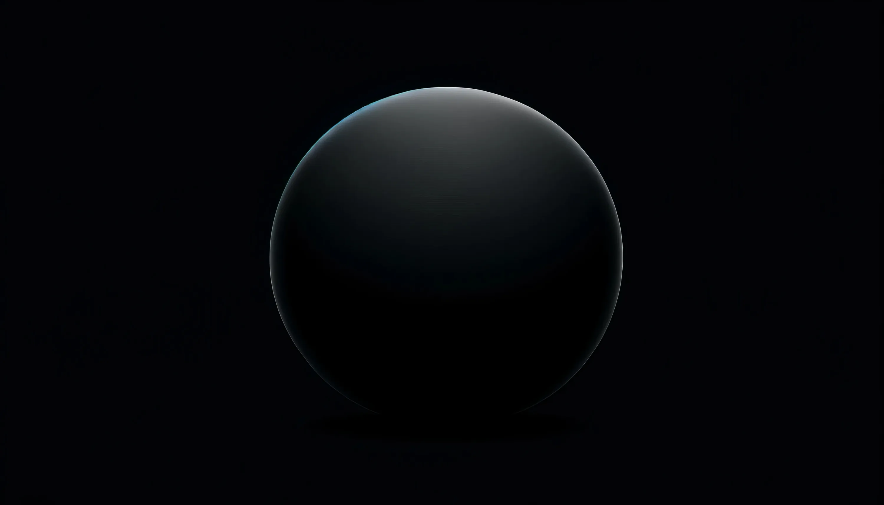 A matte black sphere sits centred in the frame, lit from above so only the top of its curve separates from the background.