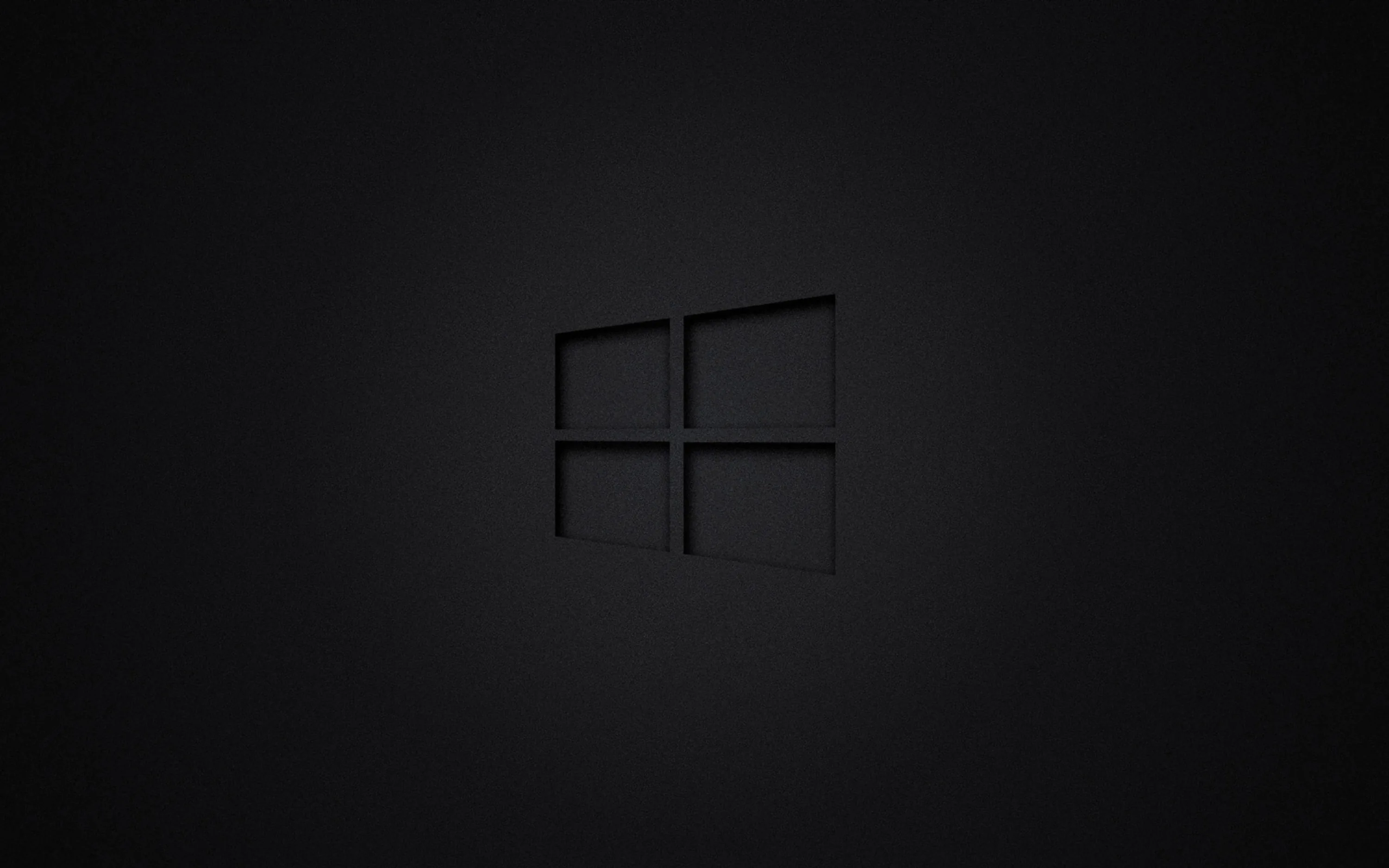 The Windows mark cut into a plain dark grey field, visible only through a soft edge shadow.