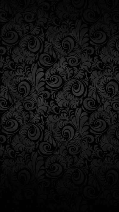Damask scrollwork repeats across the whole frame in black on black, the raised parts catching a faint grey edge so the pattern still reads.