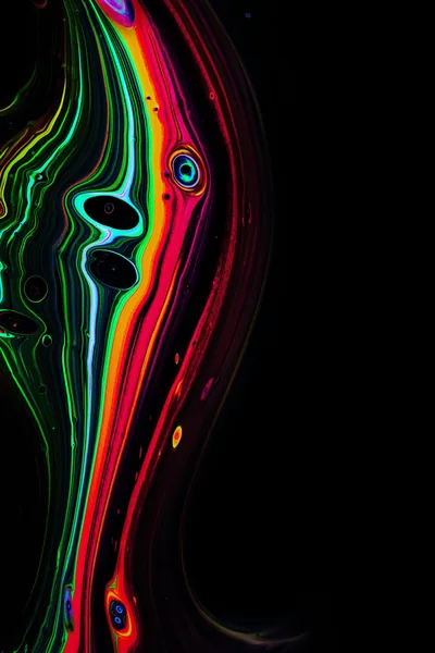 Ribbons of green, pink and red run like poured ink down the left edge; the right half stays pure black.
