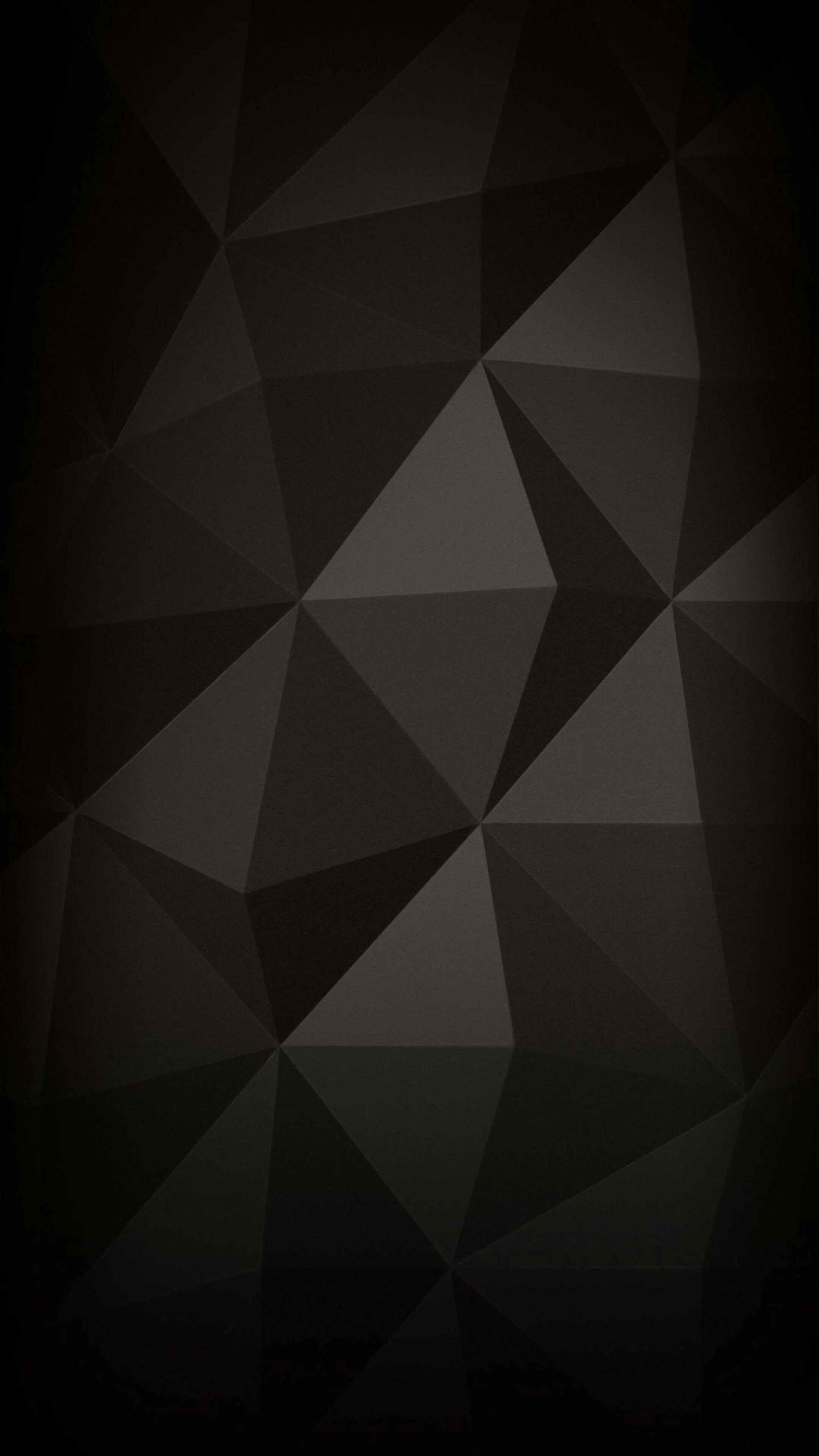 Faceted triangles tile the tall frame in shades of charcoal, the palest facets clustered near the centre while the edges drop to black.