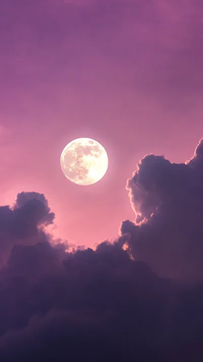 A white moon glows through mauve clouds in a pink evening sky, the haze at the bottom dark enough to keep phone icons readable.