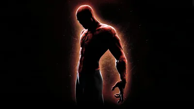 The masked figure stands in near-total black, traced only by a red glow running down one side.