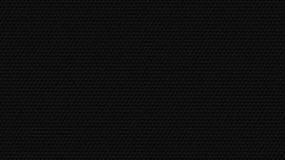 A fine hexagon mesh covers the entire frame in near-black, the pattern only readable where light grazes the upper left.