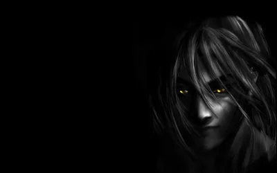 Almost the whole frame is black; only a pale face surfaces at the right edge, hair hanging loose and two yellow eyes catching the light.