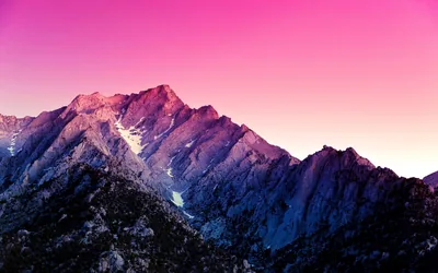 A craggy ridgeline turns violet under a flat pink-to-magenta gradient, the smooth upper half made for a lock-screen clock.