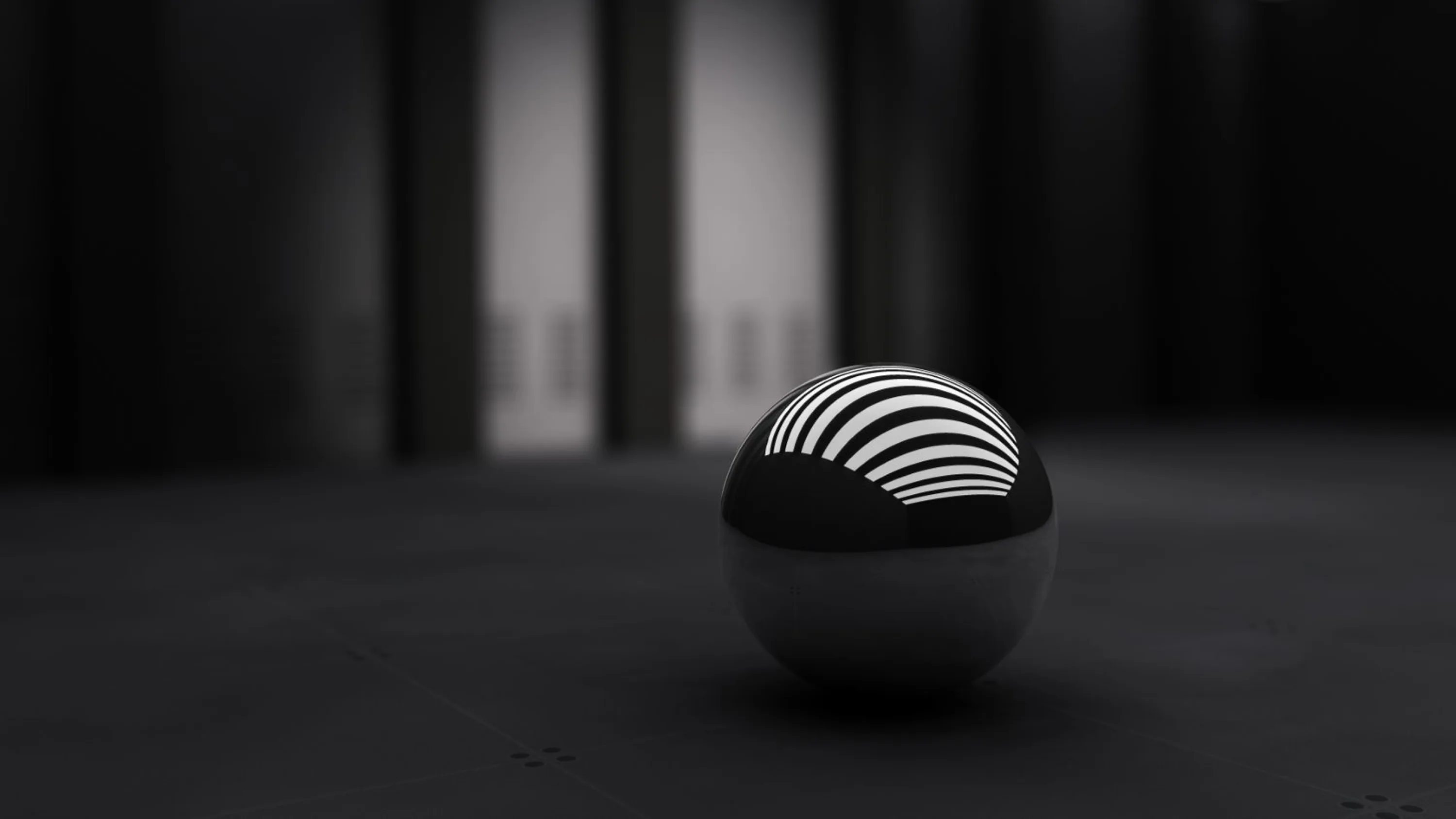 A glossy ball banded in black and white curves sits on a bare dark floor, the blurred columns behind it dissolving into grey.