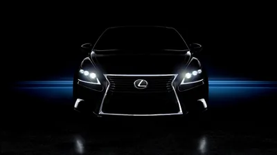 The chrome-edged spindle grille of a Lexus faces the camera head-on, a horizontal blue light streak cutting across the black behind the car.