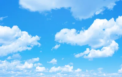 Fair-weather cumulus scattered across a saturated blue sky — nothing but cloud and blue, a clean backdrop that keeps every desktop icon visible.