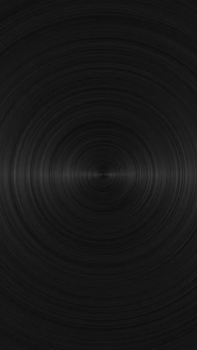 Rings of brushed metal spin out from a point just below centre, a thin bright line catching across the middle where the grain turns.