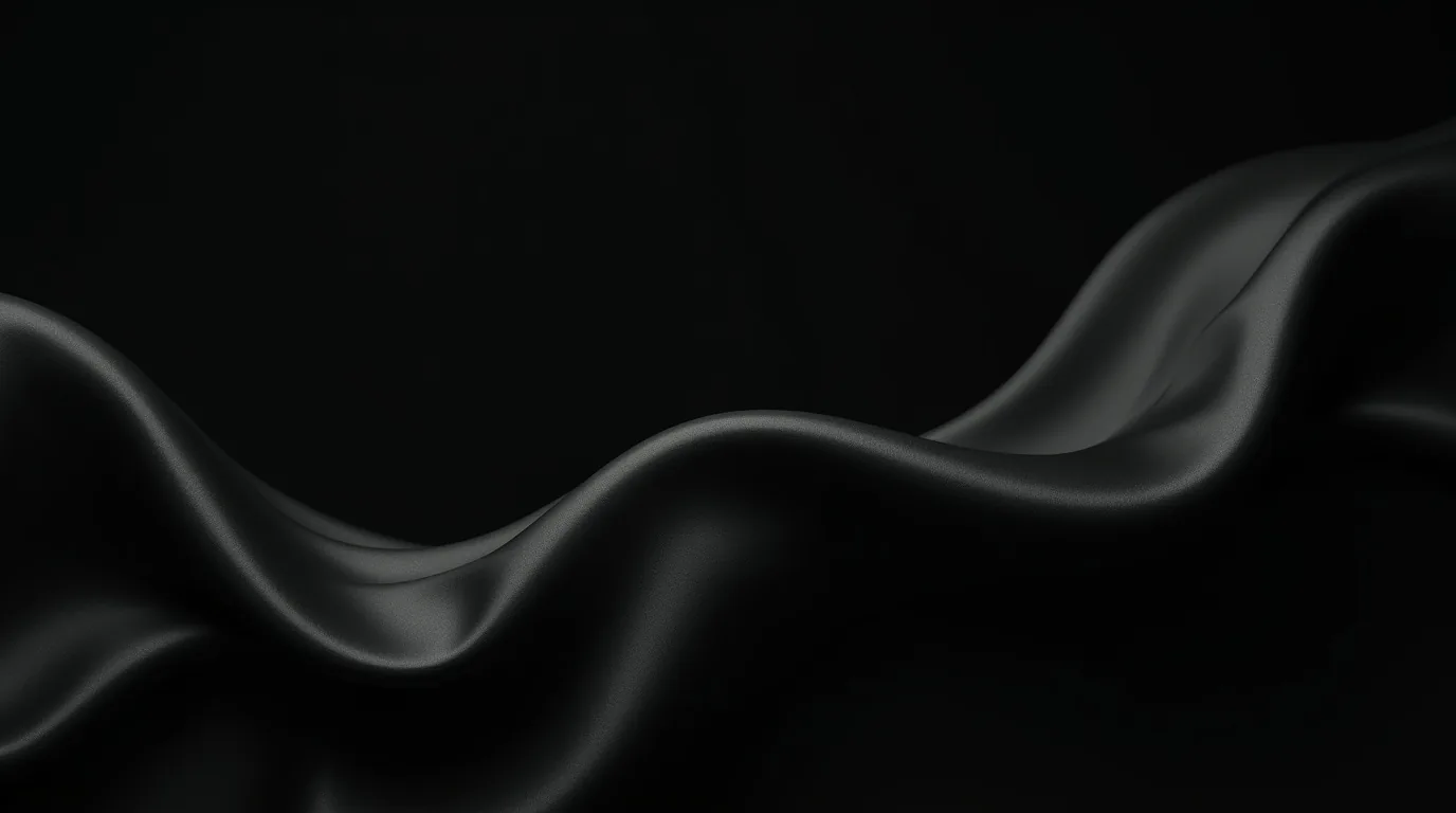 Folded silk ripples across the lower half of the frame, the sheen along each crest the only thing lifting it out of the dark.
