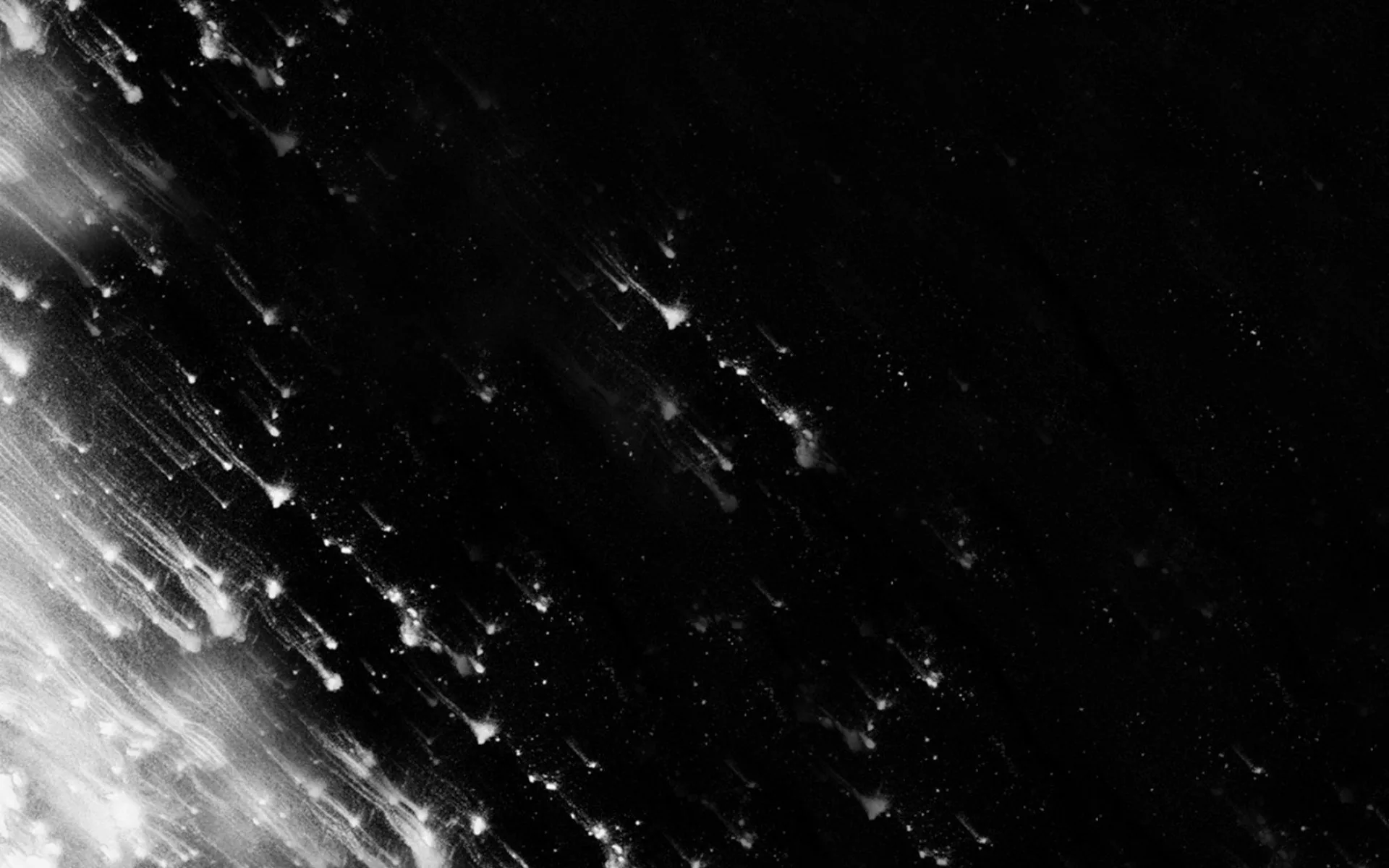 A diagonal burst of white specks and streaks sprays in from the lower left corner, thinning out into grain before it reaches the right side.