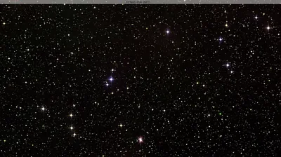 Telescope-style view of white and red pinpoint stars on black, cross spikes on the brightest few; the flat black suits battery-saving screens.