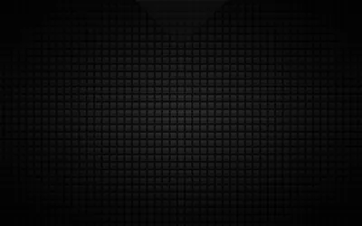 A grid of small rounded squares in charcoal grey covers the frame, lit faintly through the centre and shading down to solid black around the outside.