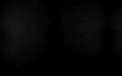 A dark canvas backdrop with two soft pools of light near the top, the rest of the frame falling into black.