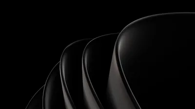 Curved black shells nest one inside the other, a thin red-brown glow tracing where each one meets the next.