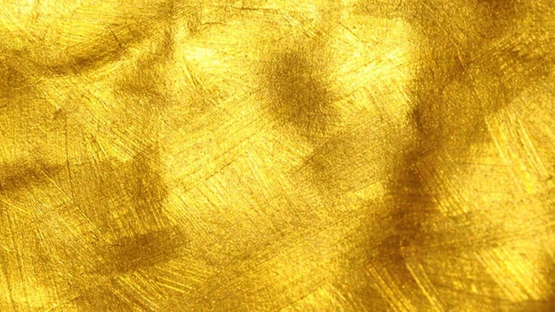 Metallic gold paint worked in crisscrossing brushstrokes, a few darker smudges drifting through the upper half of the frame.