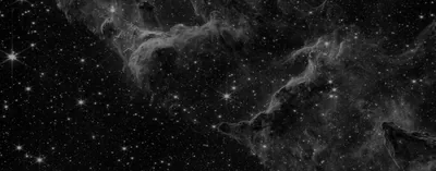 Thin nebula filaments stretch across a wide monochrome star field, one bright star flaring at the far left edge.