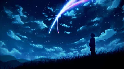 A small figure stands on a grass ridge looking up as a comet cuts across a deep blue sky packed with clouds and stars.