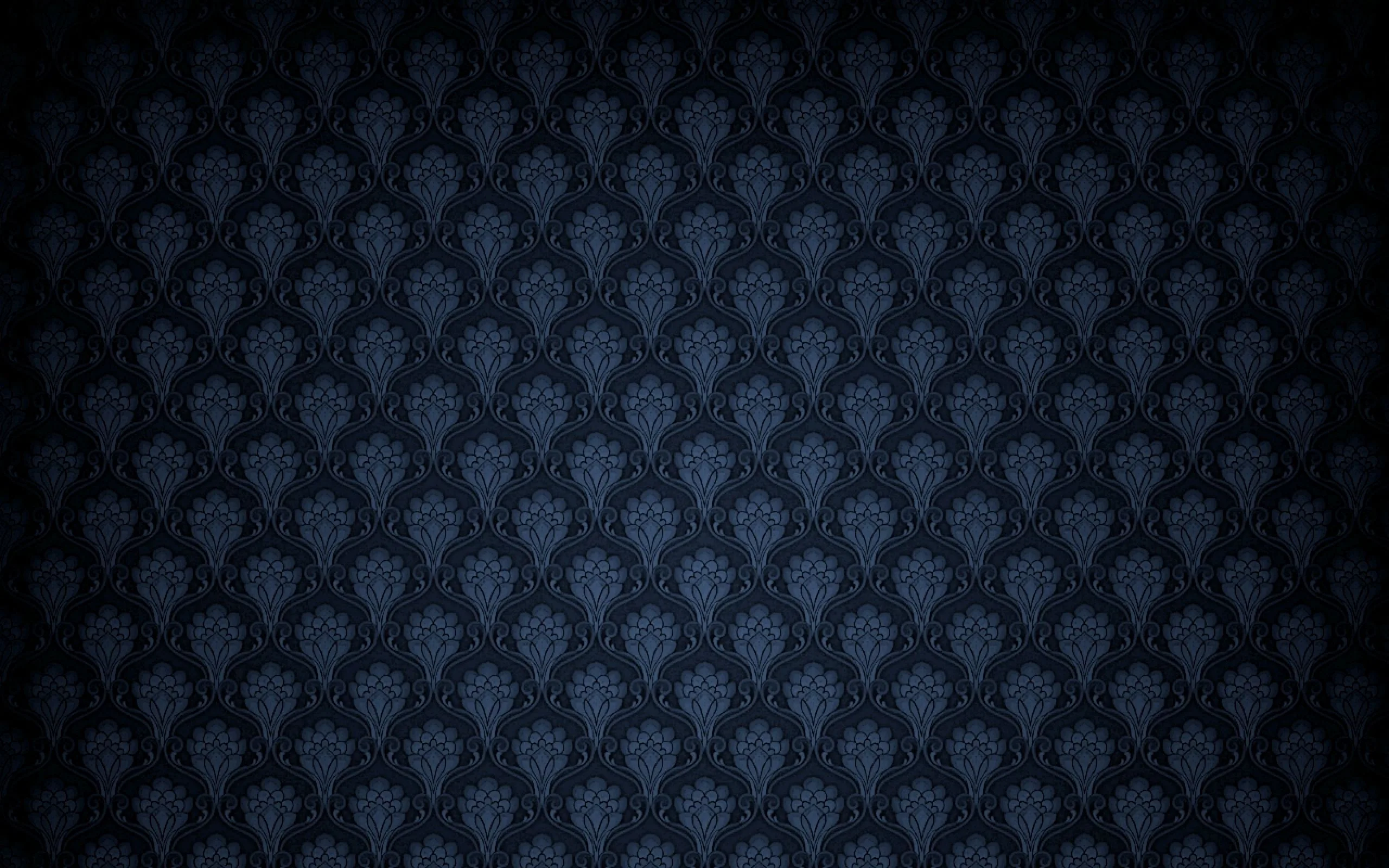 A subtle damask motif in charcoal navy, lit brightest through the middle and shaded down hard into all four corners.