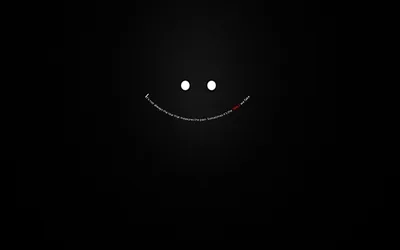 Two small white dots and a curved line of tiny type form a smile, floating on a soft black gradient.