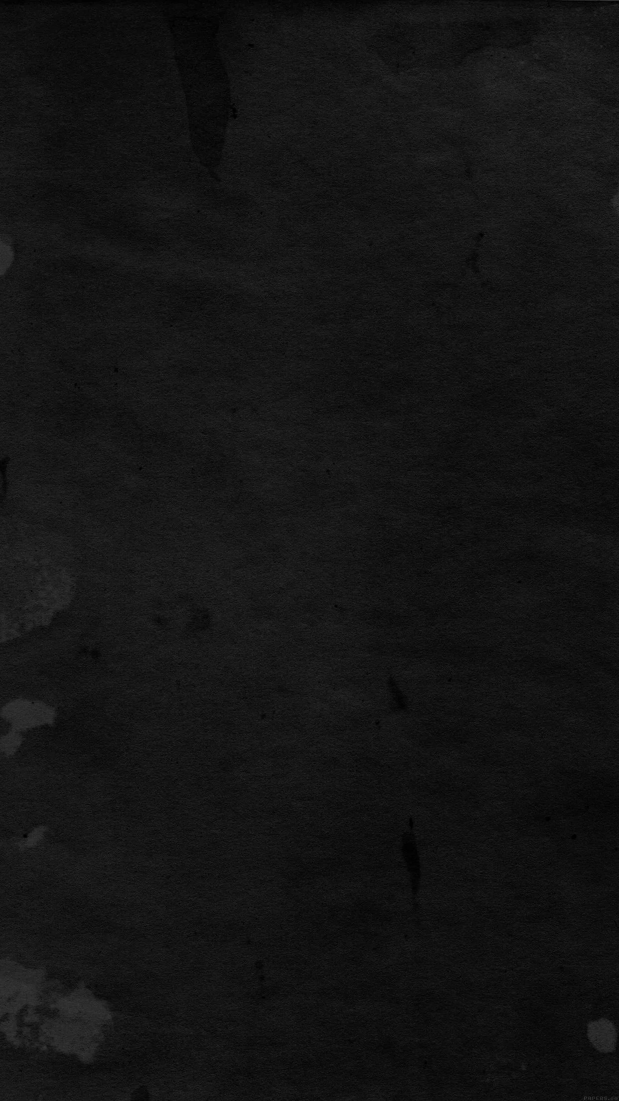 A flat wall of scuffed dark charcoal, faint vertical brush grain running top to bottom with a few lighter patches near the middle.