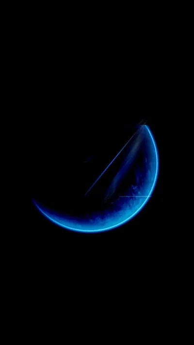 A thin blue crescent glows just below centre, and everything around it is true black, which keeps an OLED screen dark and battery use low.