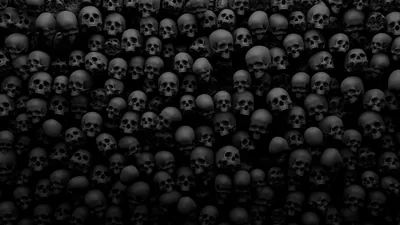 Row after row of skulls fill the entire frame in dim grey, the light falling off toward the corners so the edges go almost black.