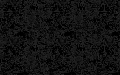 Skulls, bats and scrawled cartoon shapes tile edge to edge in charcoal on black, the detail only readable where the light lifts.