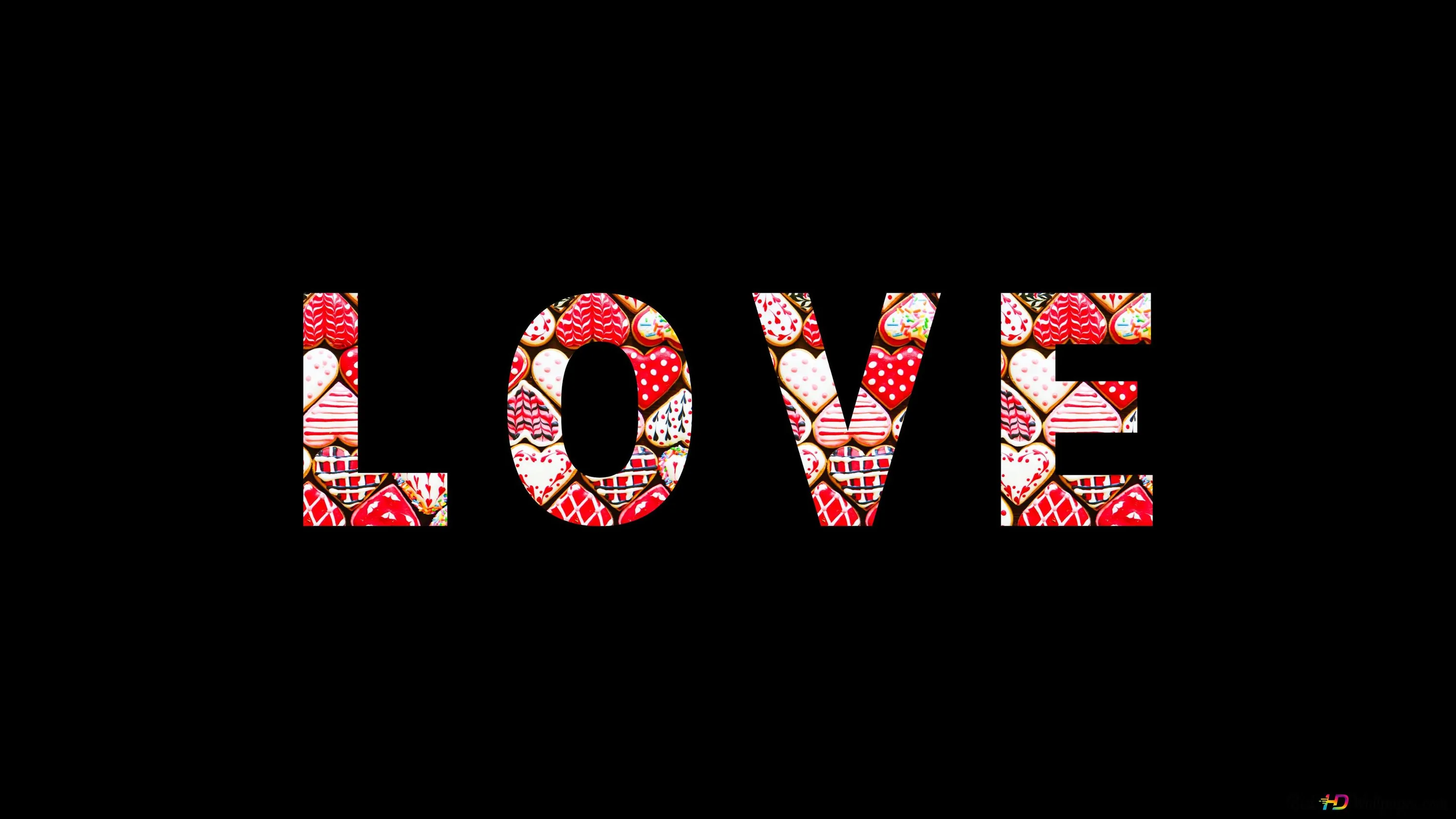 The word LOVE cut out and packed with red and pink roses, sitting large and centred with pure black around every letter.