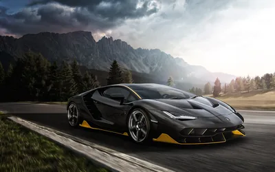 The Lamborghini rolls along an empty pass in dark grey with yellow accents on the splitter and rims, jagged peaks under grey cloud behind.