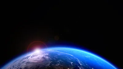 An orange flare crests the planet's rim at the lower left, the blue curve running off to the right and the upper half staying solid black.