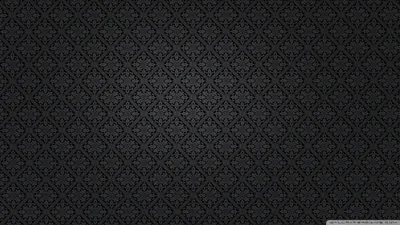 A small ornamental motif set inside a diamond trellis repeats over a soft charcoal ground, edges of the frame darkened for contrast.