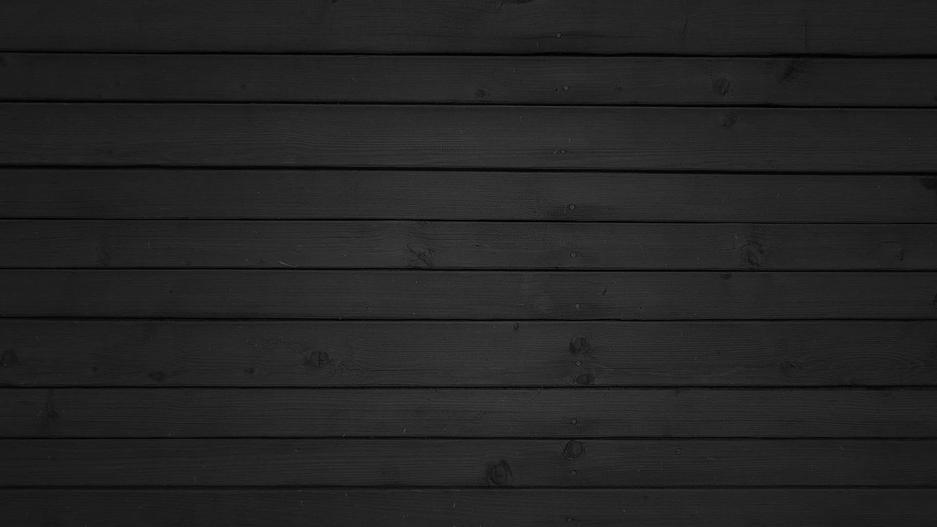 Horizontal charcoal planks run the width of the frame, grain and nail marks showing where the light grazes across the middle boards.