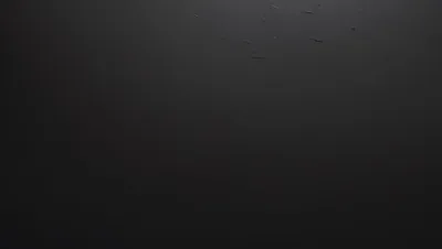 Faint scratches and dust marks catch a thin light along the top edge of a near-black panel, the lower half left completely smooth.