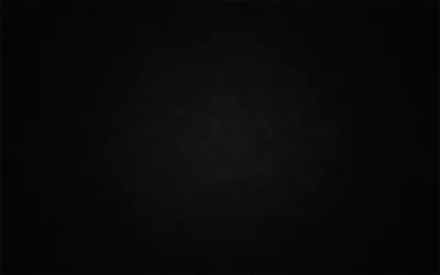 A grainy black surface marked like a wiped chalkboard, a weak light lifting the middle and the border falling away to solid black.