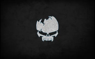 A broken skull mark sits high in the frame, drawn in speckled white grain over a rough charcoal wall with a soft vignette.