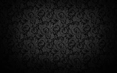 A dense baroque scroll pattern repeats over a black ground, brightest at the centre and vignetting at the corners.