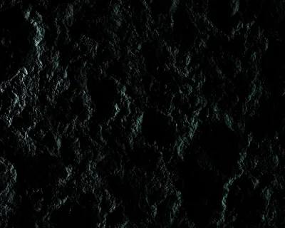 Craters pock a dark moon-like surface tinted faintly green, rim light from the upper left tracing every edge while the deepest shadow pools at bottom centre.