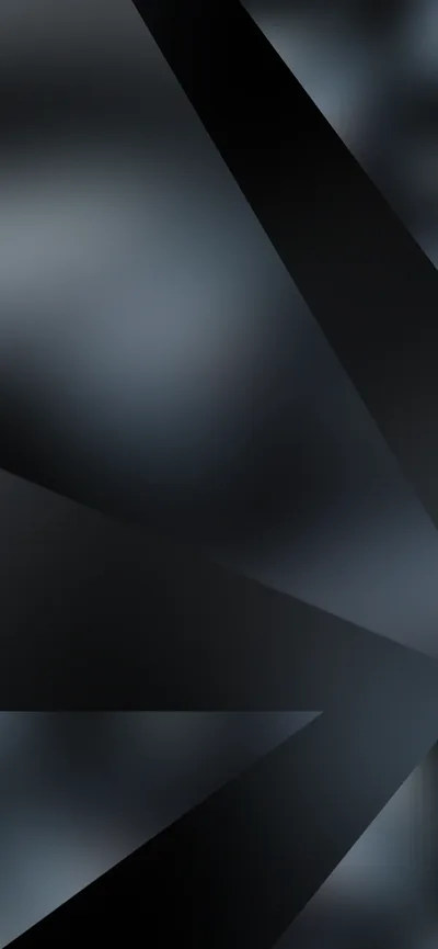 Sharp geometric shards cut across a blurred grey background, some faces matte black and others catching a cold blue sheen.