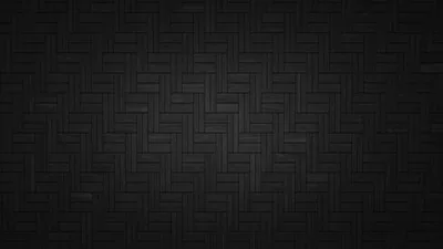 Dark tiles laid in a herringbone weave fill the frame, each block edge catching just enough light to keep the zigzag readable.