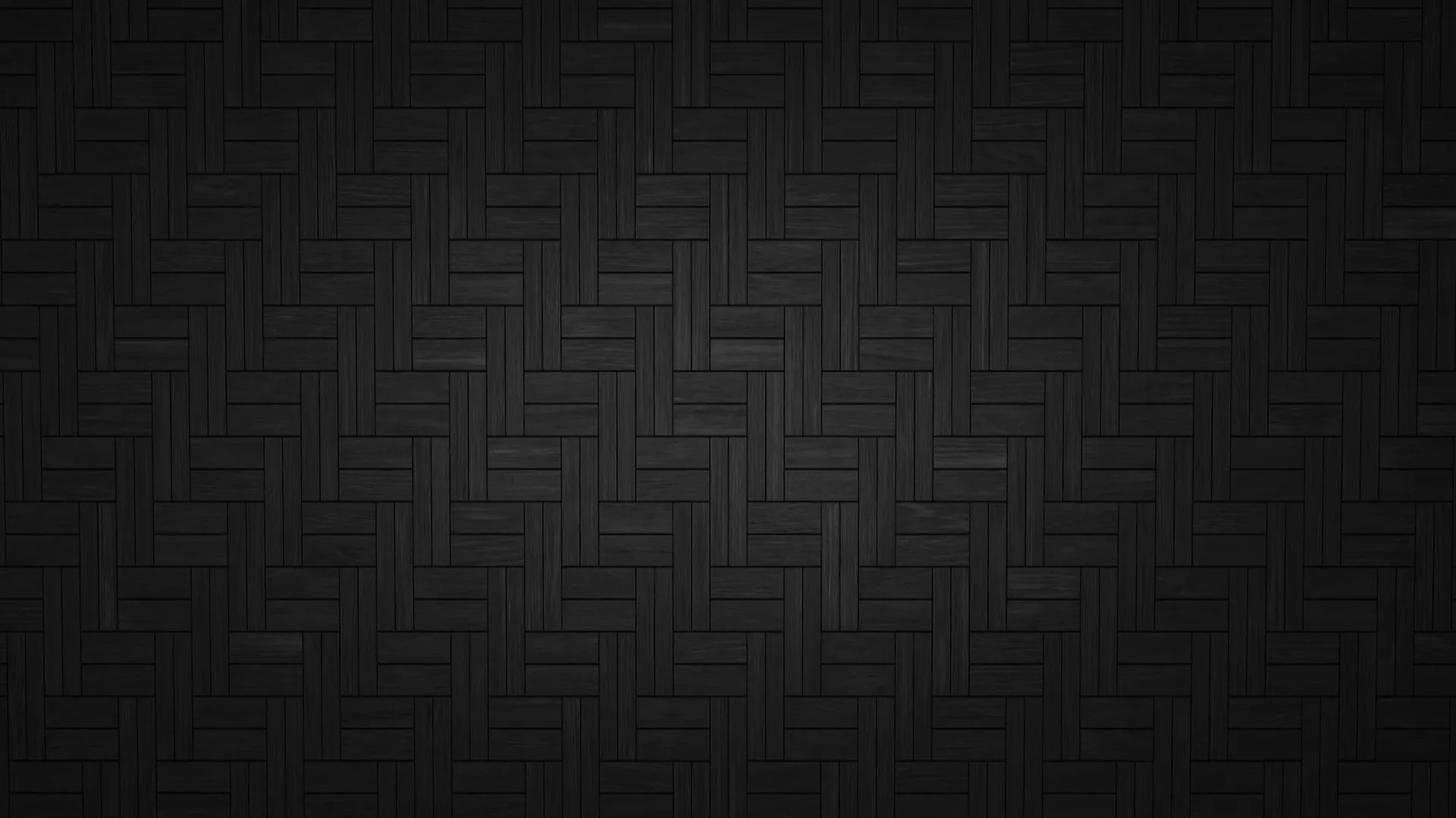 Dark tiles laid in a herringbone weave fill the frame, each block edge catching just enough light to keep the zigzag readable.