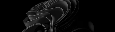 The Windows 11 bloom ribbon rendered in folded black-on-black petals, stretched across a dual-monitor width with dark space on either side.